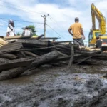 Alat berat bantuan BWSS dikerahkan untuk membersihakn lumpur yang menutup badan jalan pascabanjri bandang di Desa Wombo, Donggala, Rabu (28/5/2025). (Foto: bmzIMAGES/Basri Marzuki)