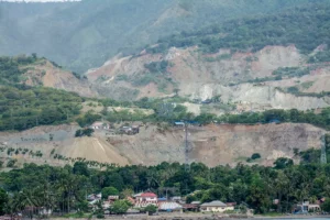 Bentangan perbukitan pesisir yang ditambang untuk material galian C bagi pembangunan Ibu Kota Nusantara (IKN) di pesisir Teluk Palu, Sulawesi Tengah, Kamis (12/6/2025). Data dari Minerba One Map Indonesia (MOMI) Kementerian ESDM, sekitar 30 juta ton batu pecah dipasok dari usaha pertambangan di Sulawesi Tengah untuk pembangunan IKN dan hingga akhir 2024 tercatat 69 izin pertambangan galian C aktif di Kota Palu dan Donggala dengan total luas lahan 1.764,41 hektare. (bmzIMAGES/Basri Marzuki)
