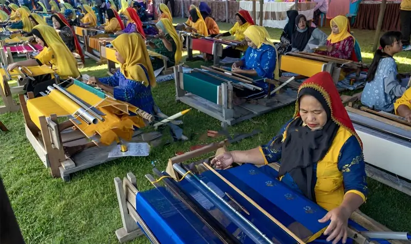 Sejumlah perajin menenun kain Donggala pada Festival Tenun Donggala di Desa Towale, Kabupaten Donggala, Sulawesi Tengah, Kamis (10/8/2023). (© bmzIMAGES/basri Marzuki)